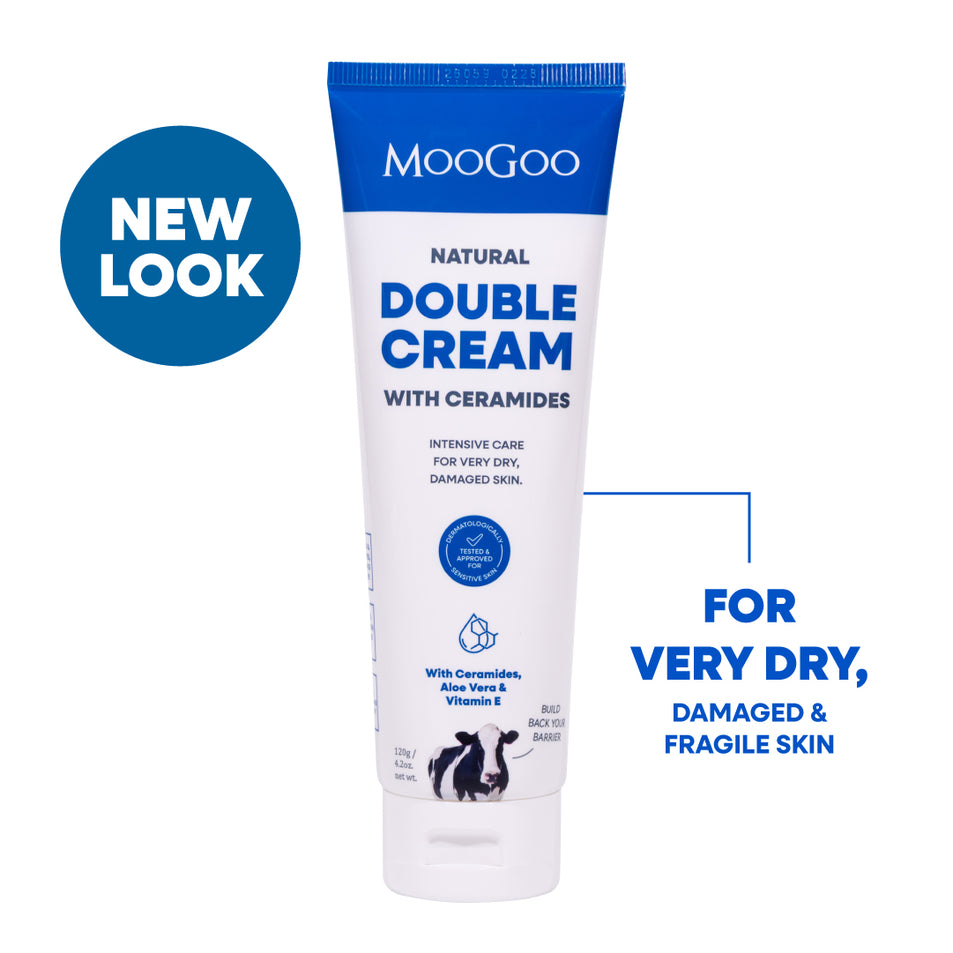 MooGoo Natural Double Cream with Ceramides tube shown on a white background with blue promotional text and a blue 'NEW LOOK' badge. The product tube is white with blue text and a blue cap band. Intensive moisturiser for very dry and damaged skin with post treatment hydration