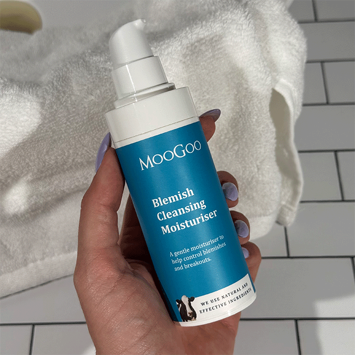 MooGoo Blemish Cleansing Moisturiser photographed with natural bathroom setting, clarifying face cream for breakout prone skin and hydration