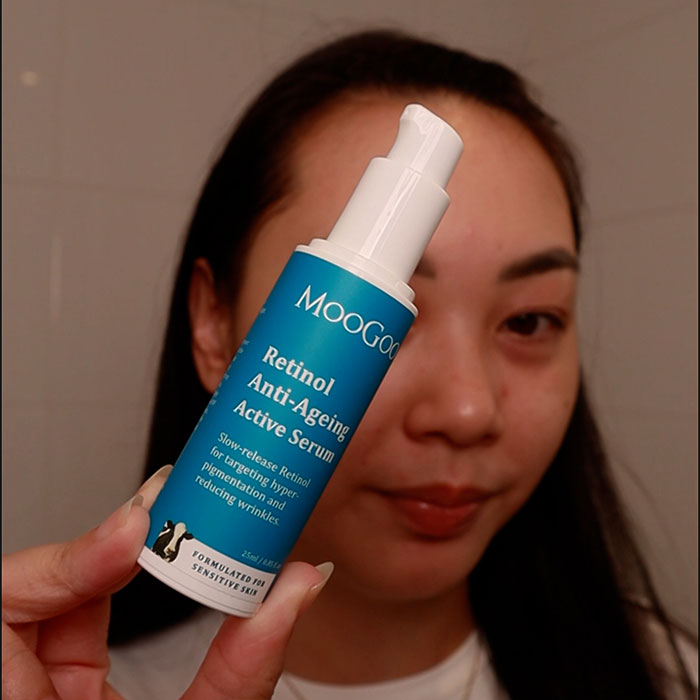 Person holding a bottle of MOOGoo Retinol Anti-Ageing Active Serum close to their face.