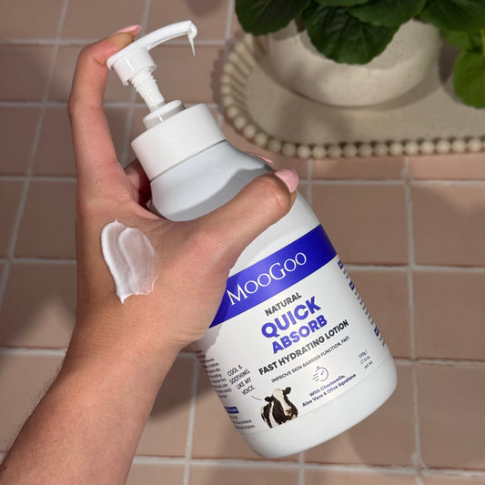 Hand holding MooGoo Quick Absorb Lotion 500g, fast absorbing daily moisturiser with aloe vera and chamomile for delicate and damaged skin