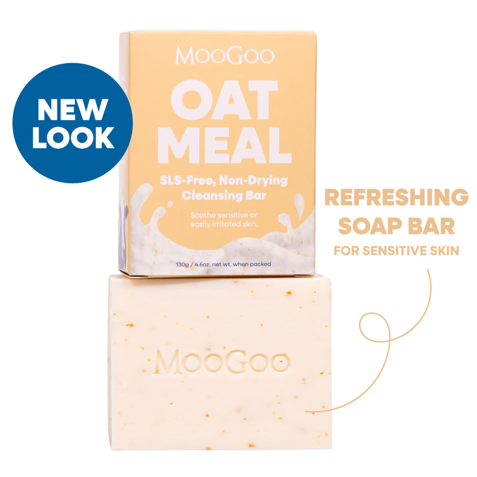 MooGoo Oat Meal SLS-free non-drying cleansing bar shown with its peach-colored packaging box and the actual bar below. Includes a blue 'NEW LOOK' badge and text reading 'Refreshing Soap Bar for Sensitive Skin'. MooGoo Natural Refreshing Cleansing Bar with Oatmeal on white background, 130g boxed soap for dull skin, gentle and SLS-free